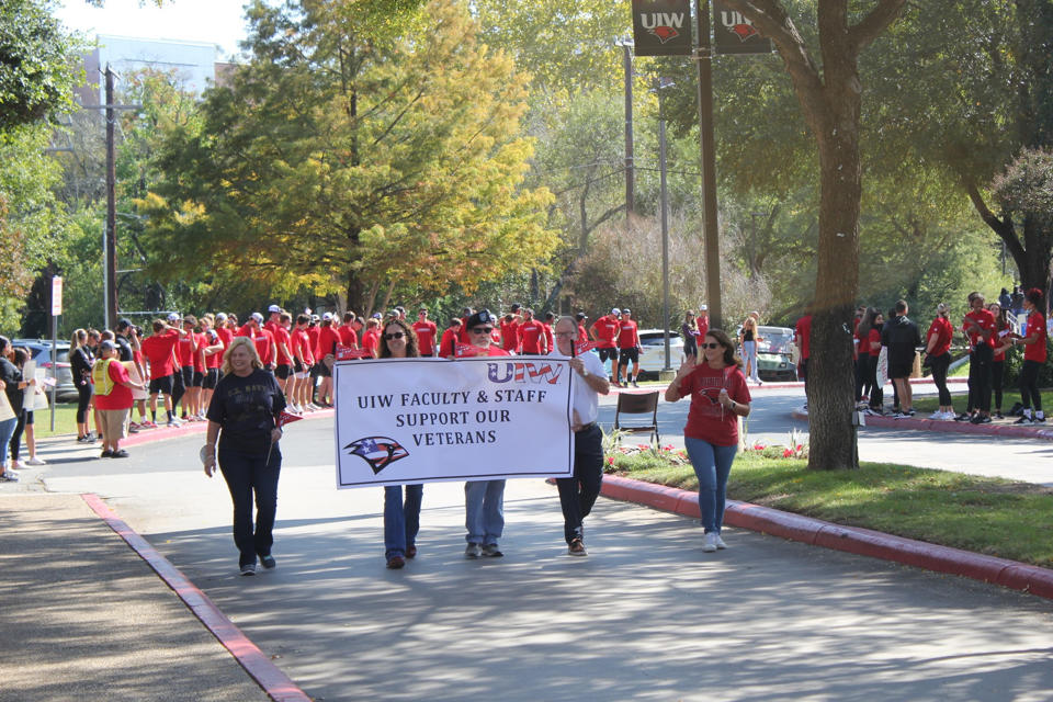 UIW faculty with veterans appreciation sign marching