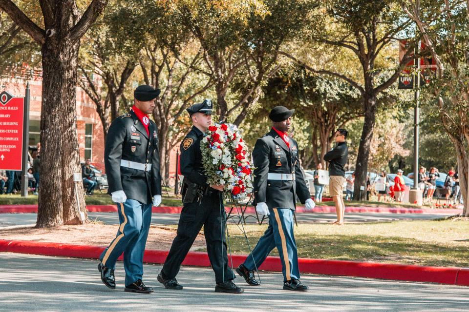 Service members standing in front of a wreath