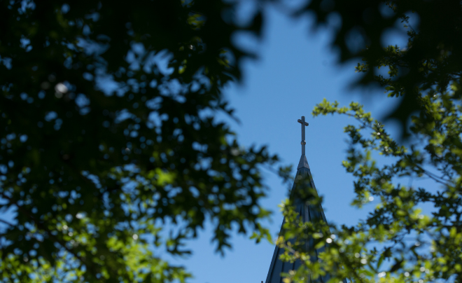 Chapel cross behind trees