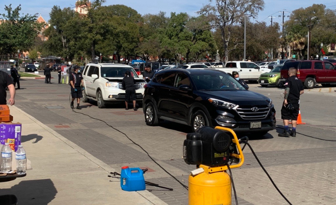 Students and employees line up to have car checks done by Valvoline employees