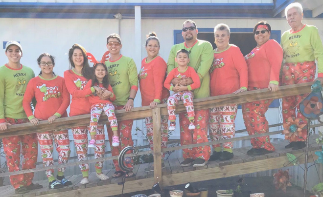 Group of family members wearing Christmas clothes smiling at the camera