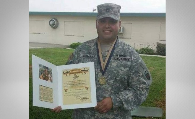 Christopher Lee Marmolejo poses with his Honorable Order of Saint Martin award