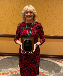 Woman smiling and holding an award