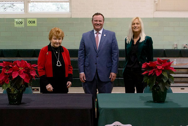 three leaders standing behind tables