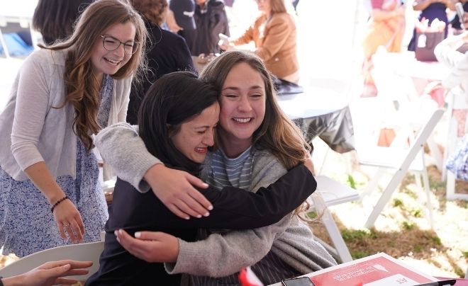 Two women hug in celebration of match day