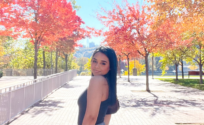 Brittnay Hernandez in front of fall foliage