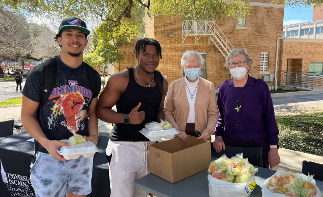 Students pick up their Fish Fry plates from two Sisters