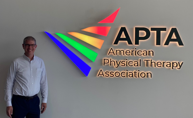 Chad Jackson in front of the American Physical Therapy Association sign