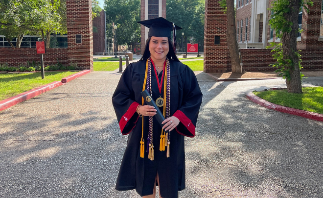 Daniela Gonzalez poses in regalia in front of the clock tower