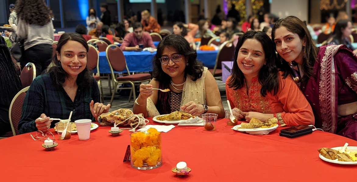 Four women smile at the Diwali event