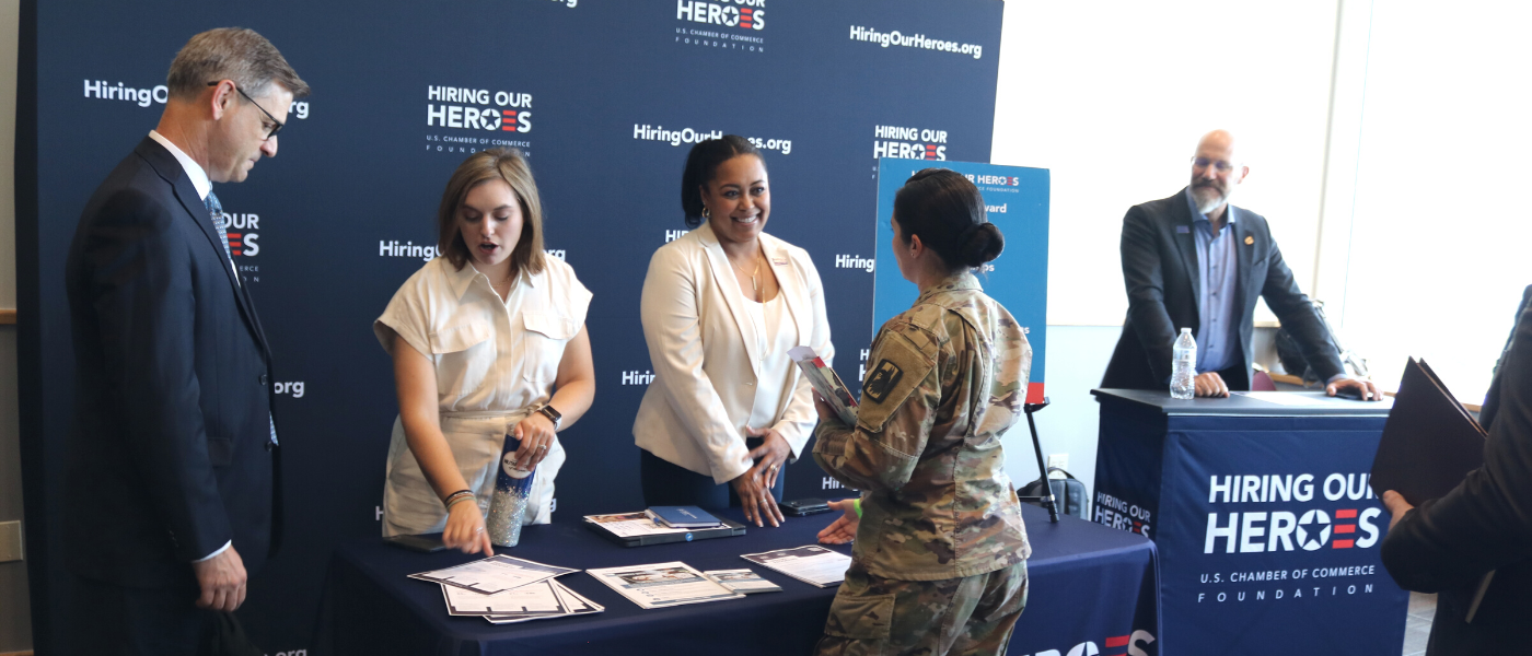 Military member speaking with staff at the Hiring Our Heroes table
