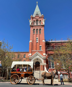 Covered wagon traveling in front of the Chapel of the Incarnate Word