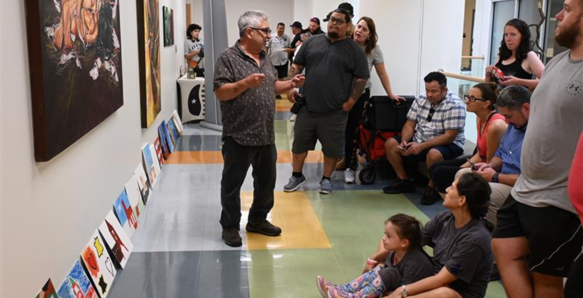 Dr. Miguel Cortinas talking to artists in the hallway