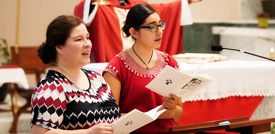 Two ladies singing in choir for mass