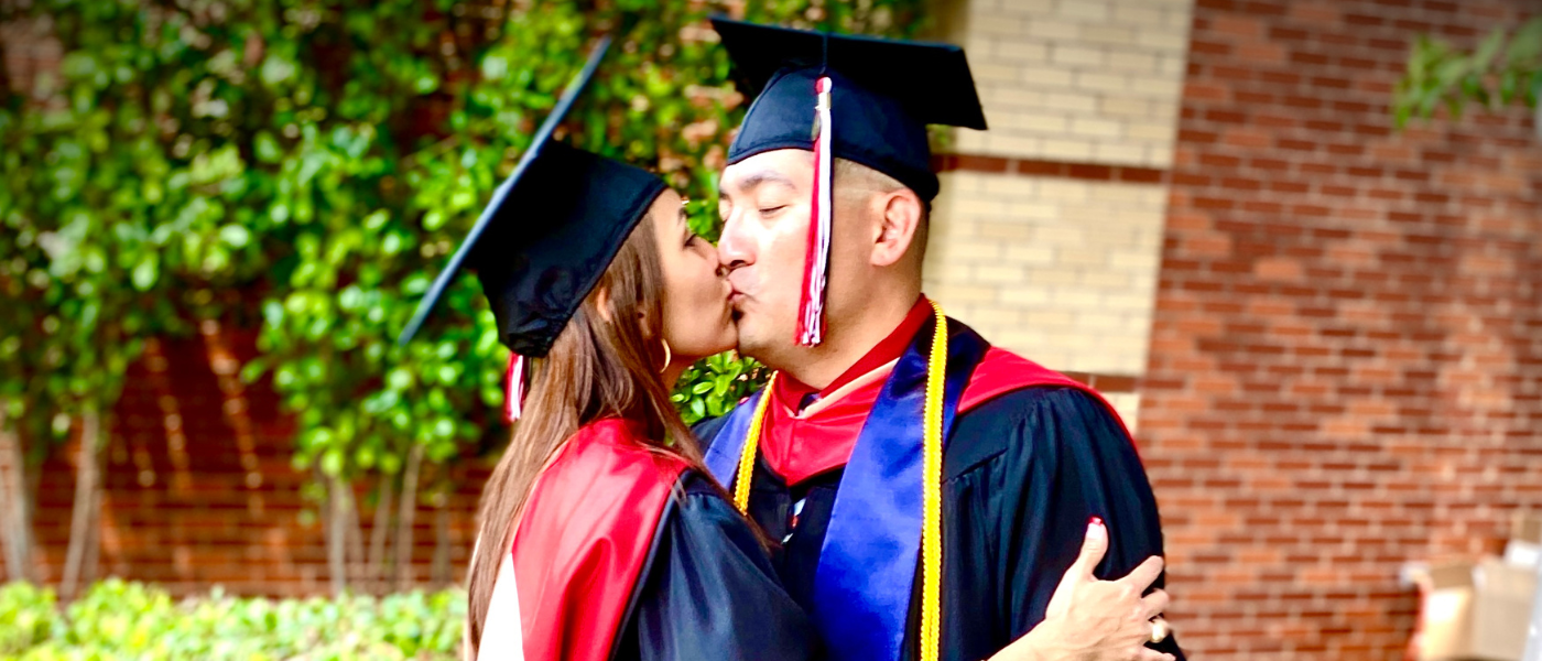 Roxanne and Eddie Perales kiss in regalia