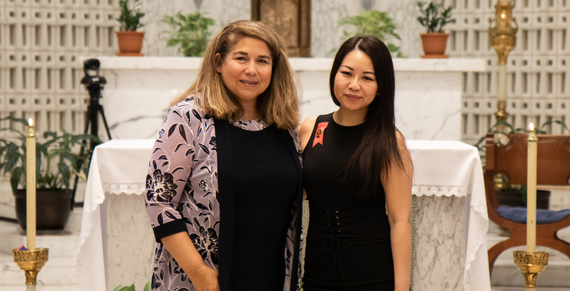 Dr. Yvonne Davila pinning a graduate in a black dress