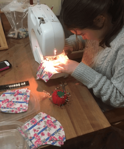 Student sewing masks