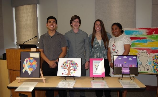 Additional students pose with their artwork during the gallery opening