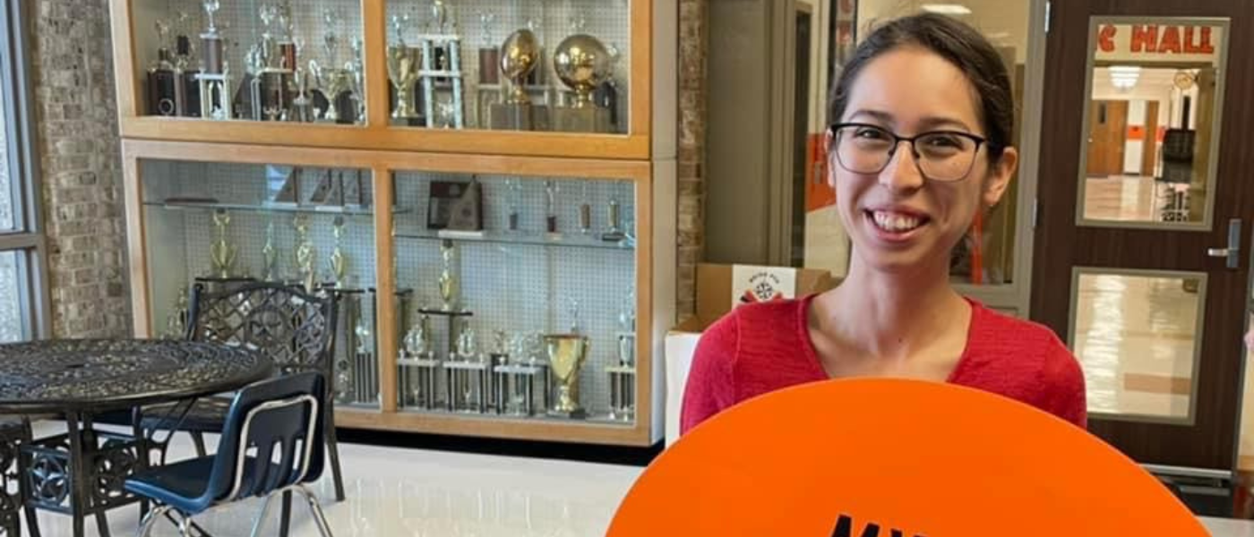 Rocio Montelongo holds an orange sign that says my first day of school