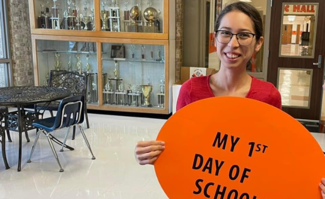 Rocio Montelongo holds an orange sign that says my first day of school