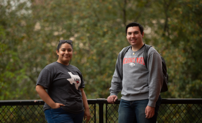 Two students smile at the camera