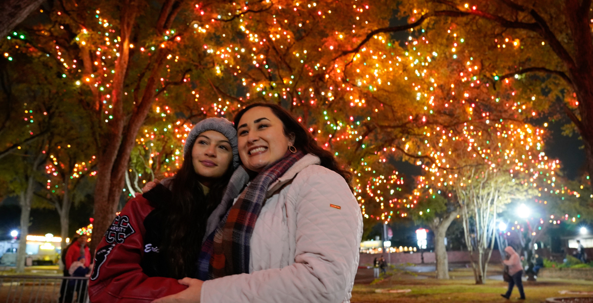 Two women smile under the lights
