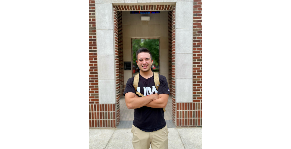 Student poses in front of the clocktower