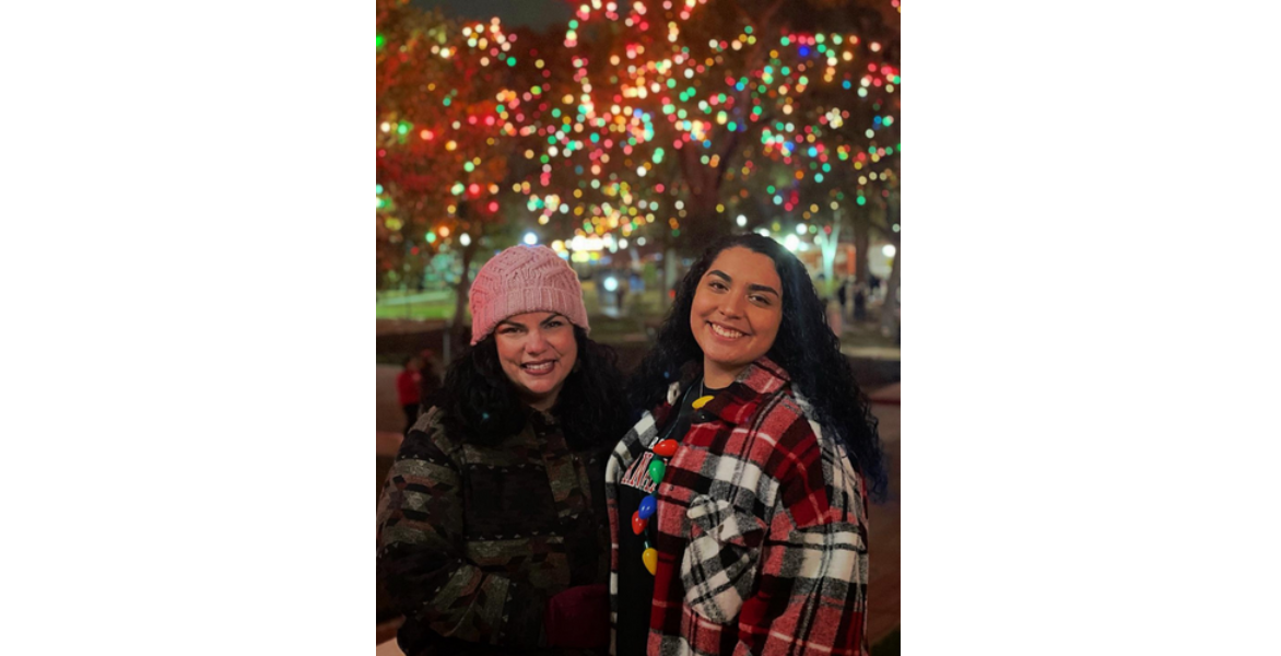 Woman in pink hat and woman in red plaid coat smiling