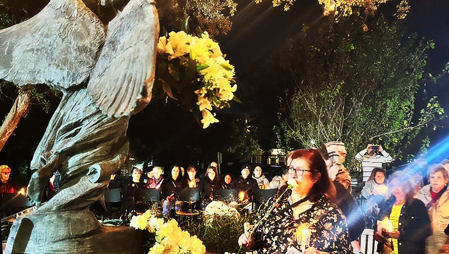 Lady praying at Angel of Hope statue