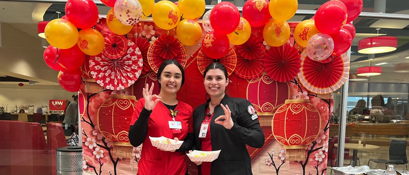 Two students posing in front of red lanterns