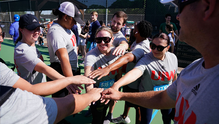 Staff members in group with hands together