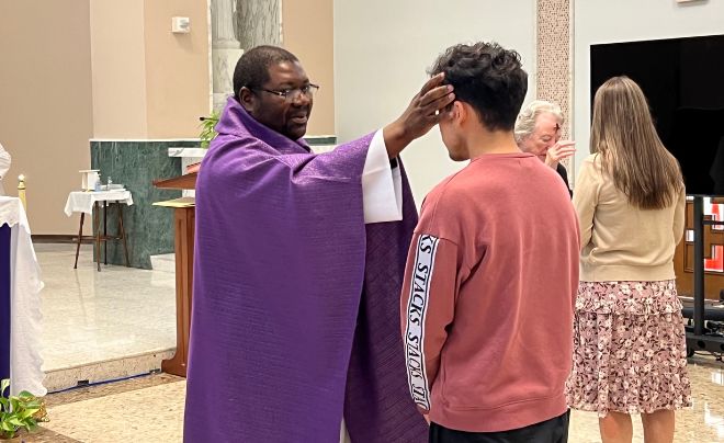 Fr. Hector puts ashes on student's forehead