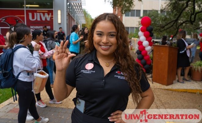 UIW student holding up the Cardinal sign