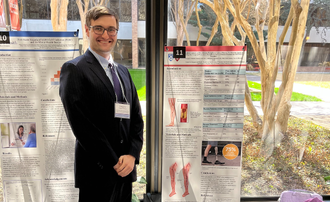 Greg Williams stands next to his research poster
