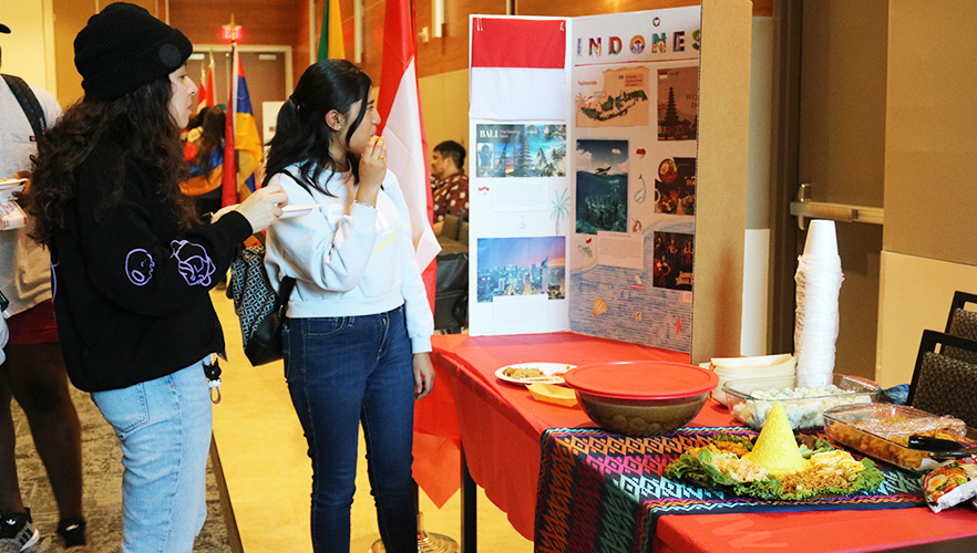 Student at International Education looking at booth presentation