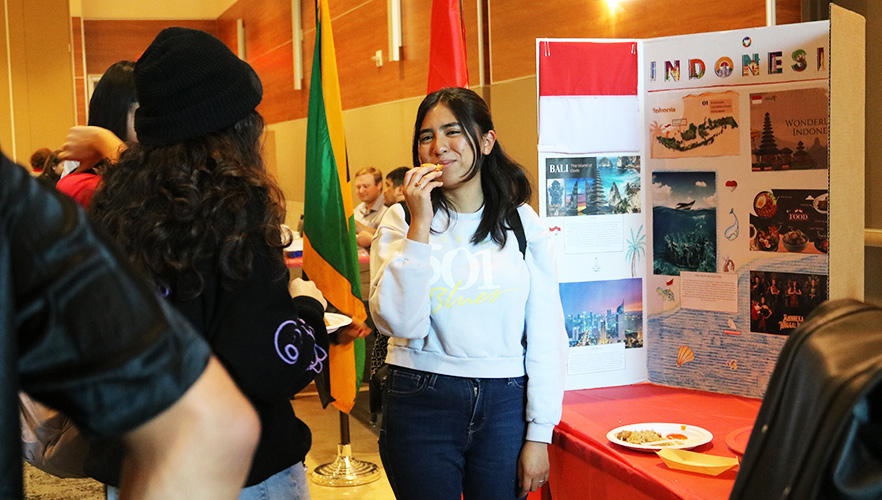 Student at International Education event eating by booth