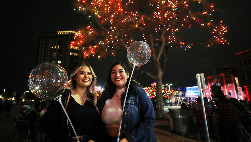 two guests at light the way holding balloons