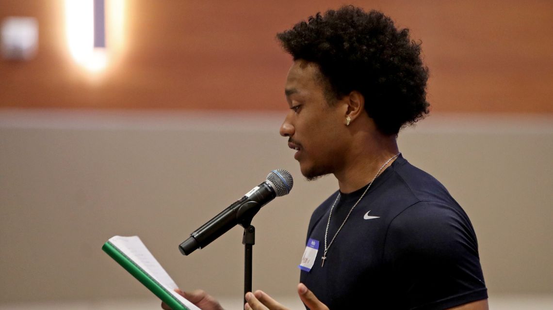 Man reading book at microphone