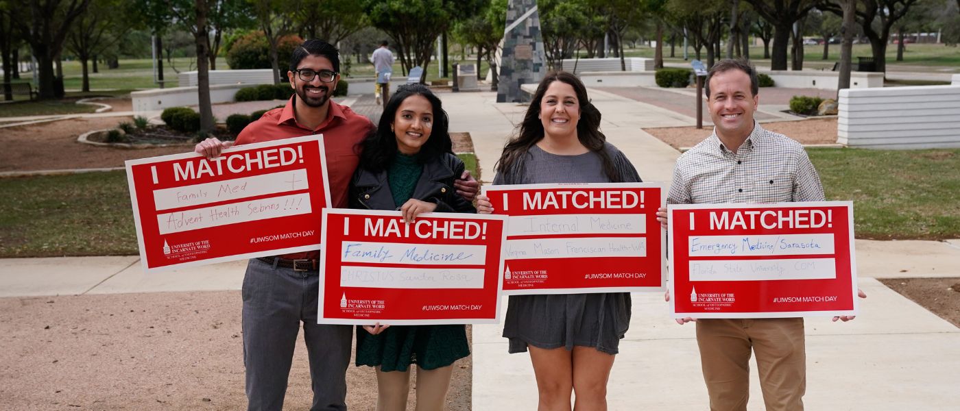 Four people holding signs that say I Matched