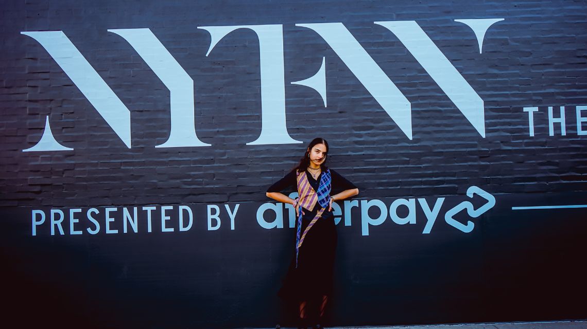 Maya Kanawati in front of NYFW sign