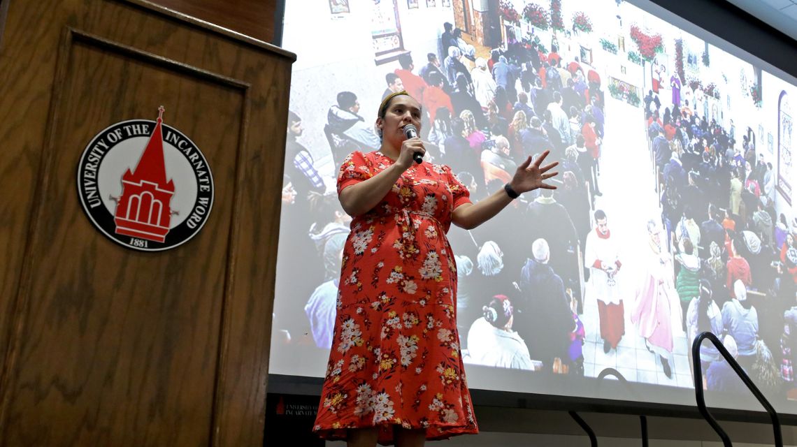 Dr. Nichole M. Flores speaking in front of the screen