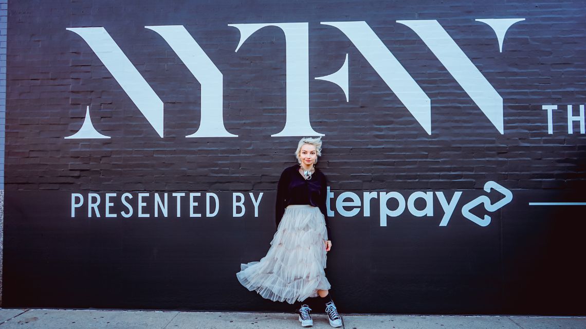 Sarah Cox in front of NYFW sign