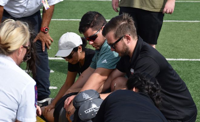 Dr. Sterling Jeffries and Dr. Edgardo Rivera Lopez work on an athlete