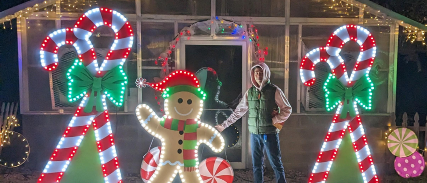 Student standing in front of Christmas lights