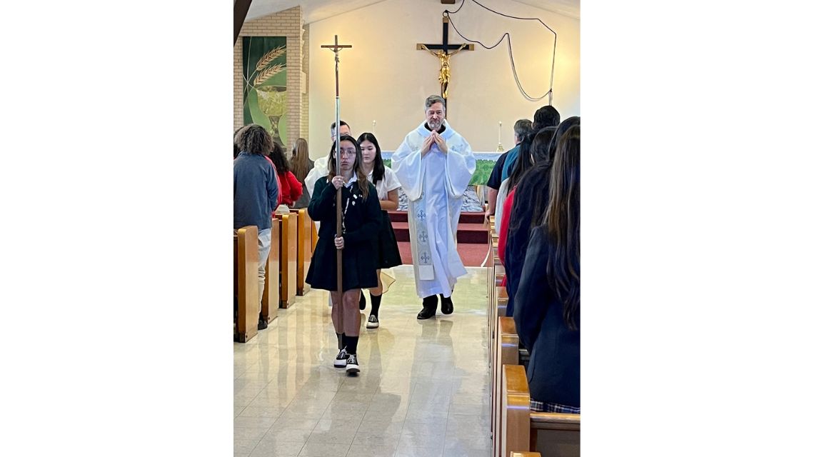 Student carrying a cross during recessional