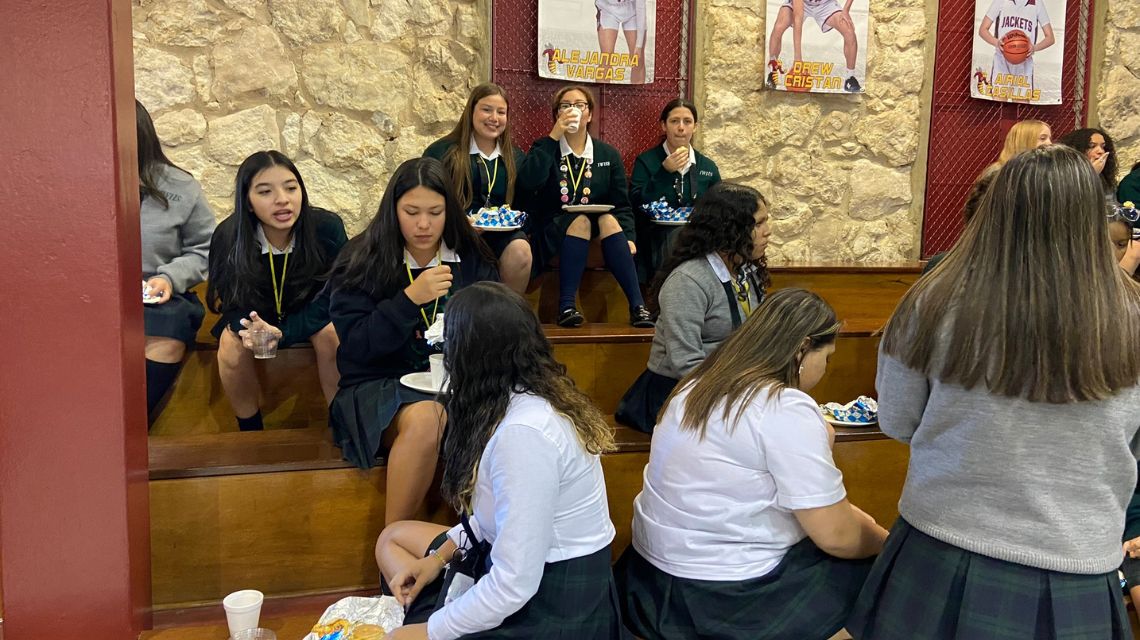 Students in green jackets eating