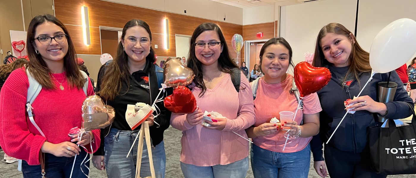 Students holding heart-shaped balloons