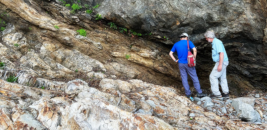 Faculty members studying the rocks 