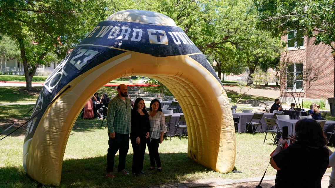 Three people under a blow up ring