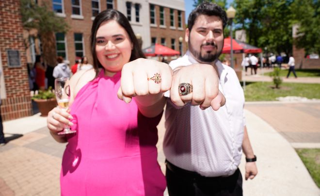 Two students show off their class rings